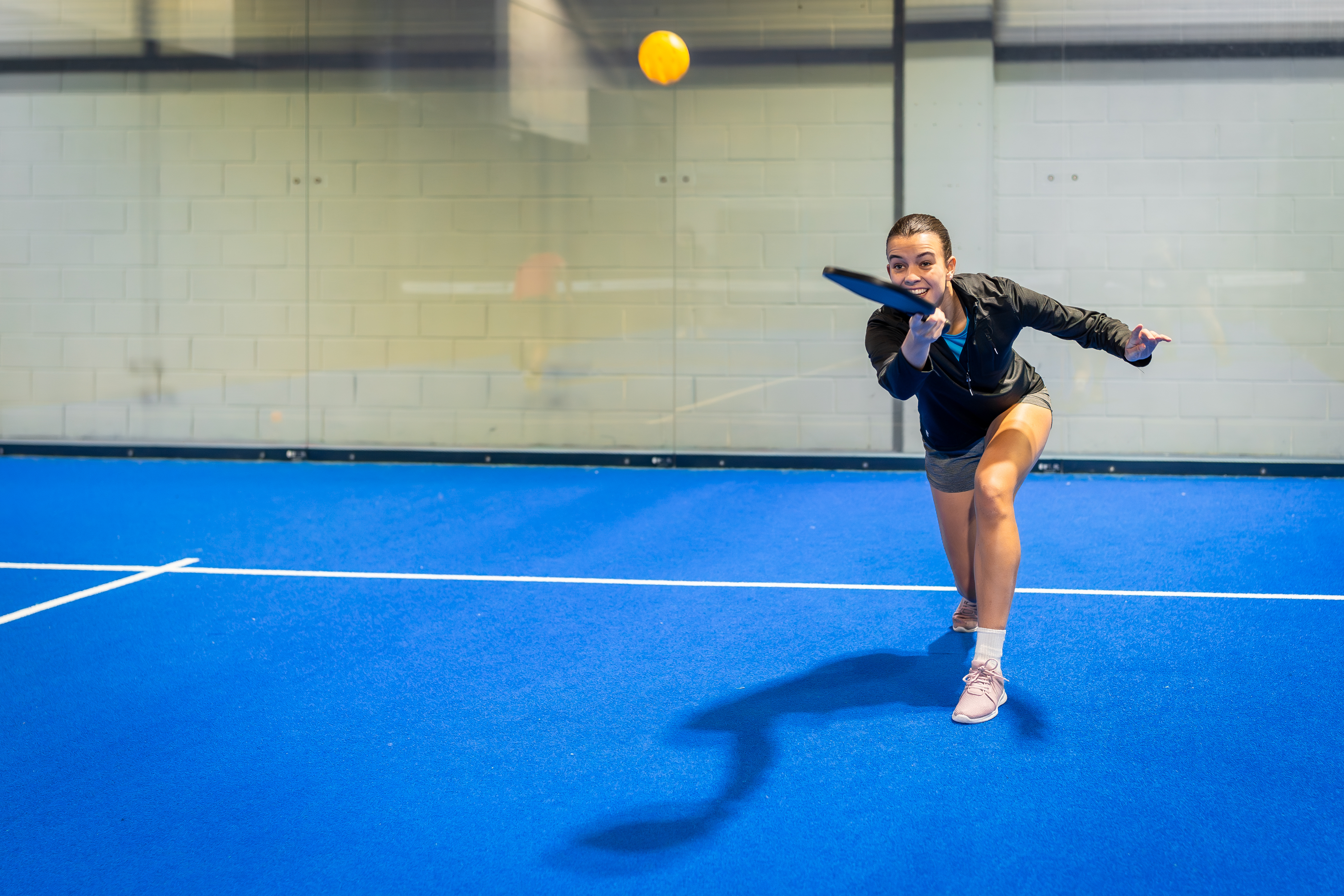 A group of four friends smiling and socializing around a table with drinks